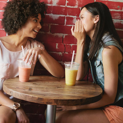Two women talking amd drinking smoothies at a local cafe