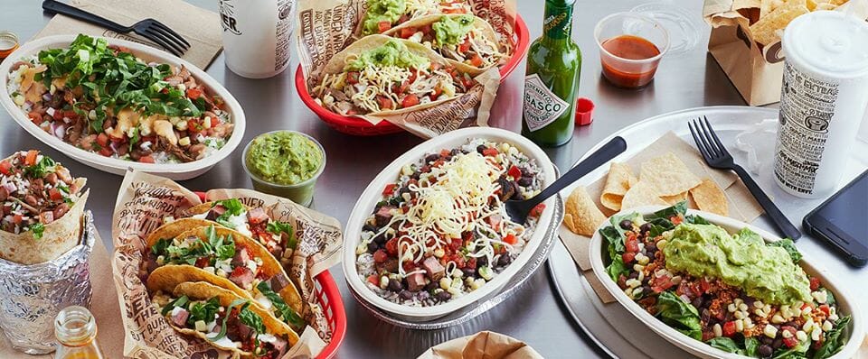 Plates of Chipotle burritos, tacos, and salad