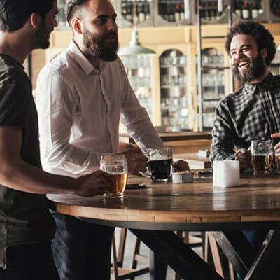 Friends sit around a table at a bar